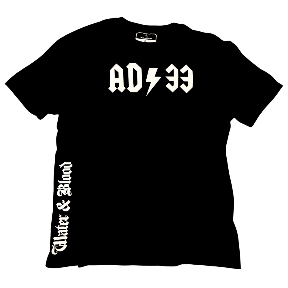 A black short-sleeve Christian t-shirt with 'AD33' printed in white across the chest, featuring a lightning bolt between the 'AD' and the '33', mimicking the ADCDC band logo. The wearer's right rib area displays 'Water & Blood' in a matching white Gothic font.