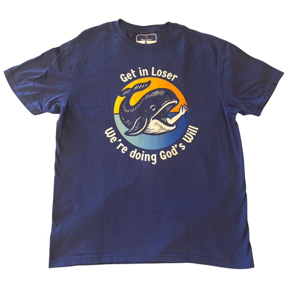 A navy blue short-sleeve t-shirt with a graphic print on the front. The graphic features a stylized fish illustration with the prophet Jonah's arm protruding from its mouth in a waving gesture, inside a yellow, orange, and blue circular design, with the text 'Get in Loser' above and 'We're doing God's Will' below in white.