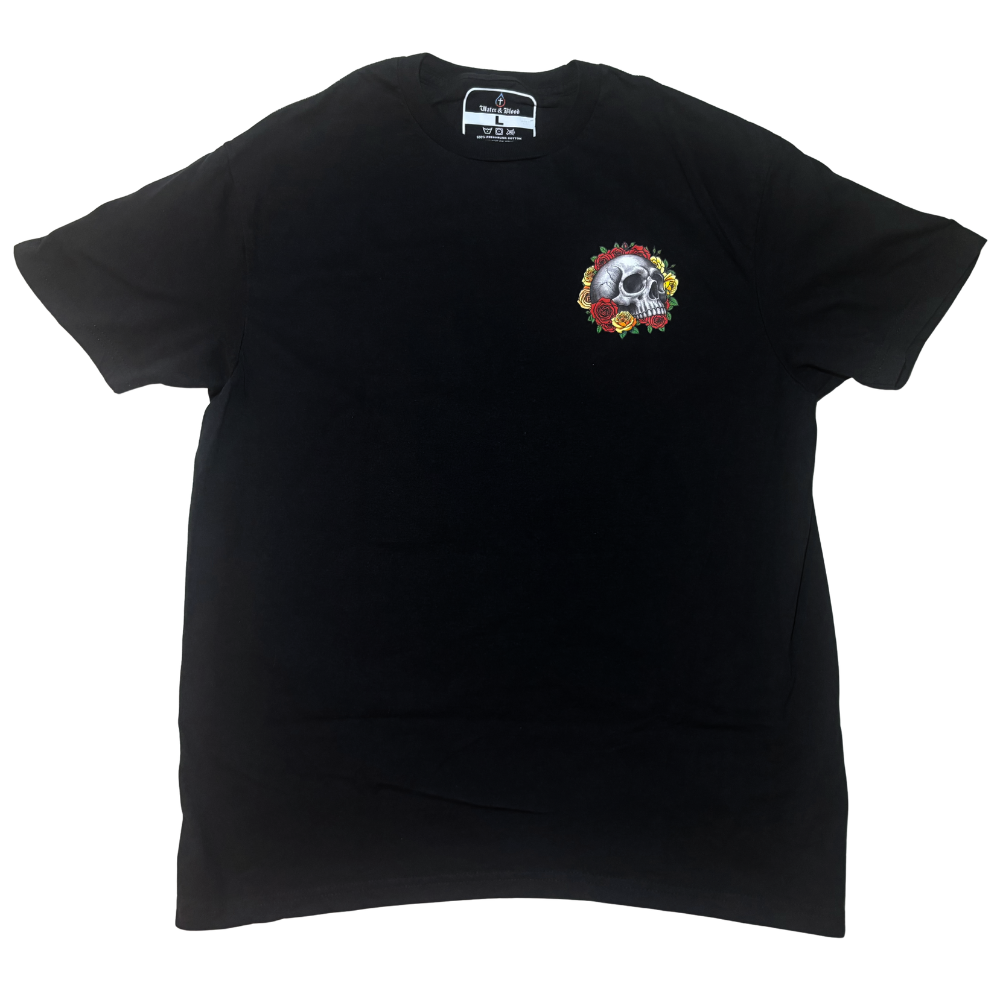 A black short-sleeve Christian t-shirt with a colorful skull graphic surrounded by red and yellow pop-art style roses on the left chest, displayed flat against a white background.