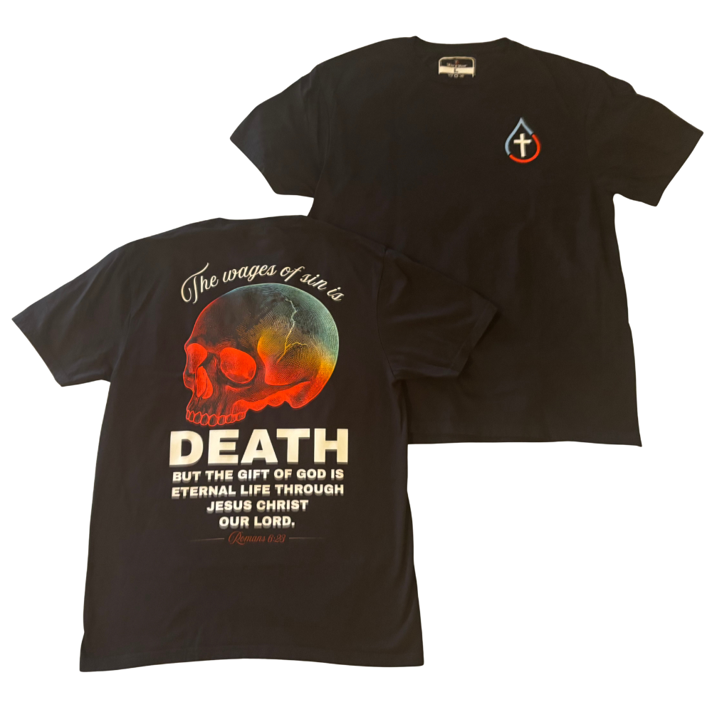 Black short-sleeve t-shirt shown from both front and back. The front features a small red and blue teardrop shape with a white Christian cross logo on the left chest. The back design depicts a red, gold, and teal gradient skull with bold white text that says 'The Wages of Sin is DEATH but the Gift of God is Eternal Life Through Jesus Christ Our Lord - Romans 6:23'