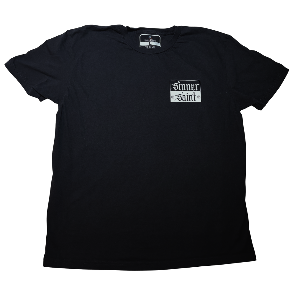 A black short-sleeve t-shirt with a small white graphic on the left chest that reads 'Sinner' on the top and 'Saint' on the bottom in a Gothic font with 2 small Maltese crosses flanking the word 'Saint'. This t-shirt highlights the duality of Christians as both sinners in this life and fully righteous children of God through Jesus Christ's imputed righteousness