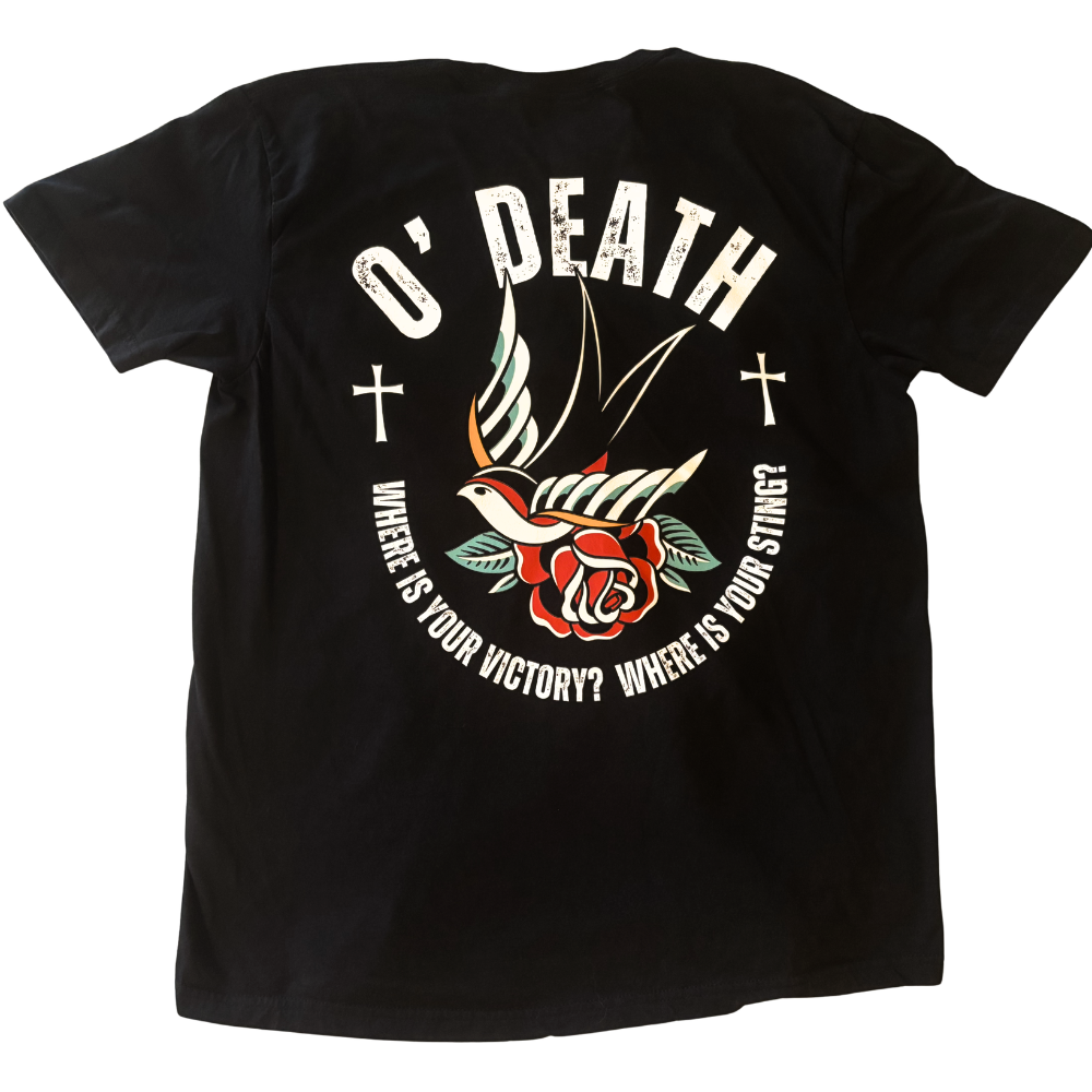 A black short-sleeve t-shirt shown flat against a white background, featuring a large Christian graphic print on the back with the words 'O' DEATH' and 'WHERE IS YOUR VICTORY? WHERE IS YOUR STRING?' surrounding a traditional tattoo-style sparrow, rose, and cross design.
